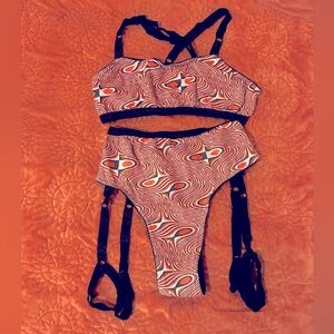 Full Set of Solstice Intimates Lingerie with red, black and white swirl pattern.